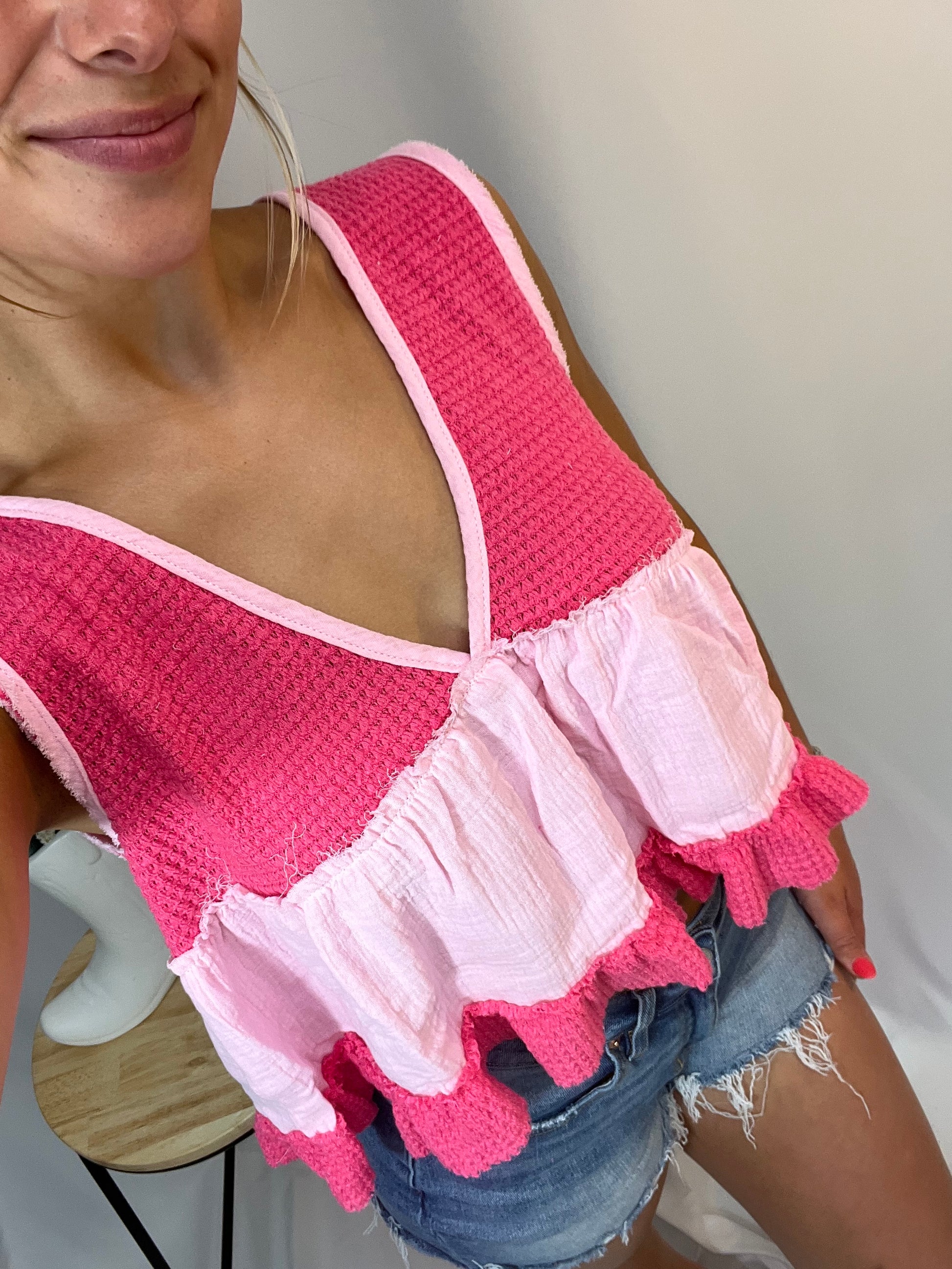 Close-up of bright pink and baby pink ruffle sleeveless thermal babydoll tank, women’s cropped waffle knit top with flowy fit