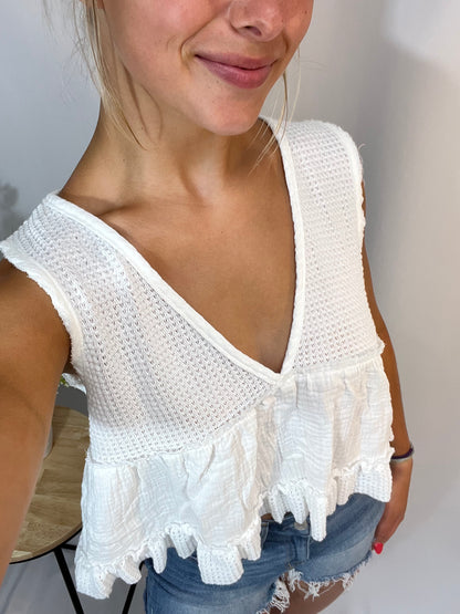 Close-up of white sleeveless thermal babydoll tank, women’s cropped waffle knit top with flowy fit