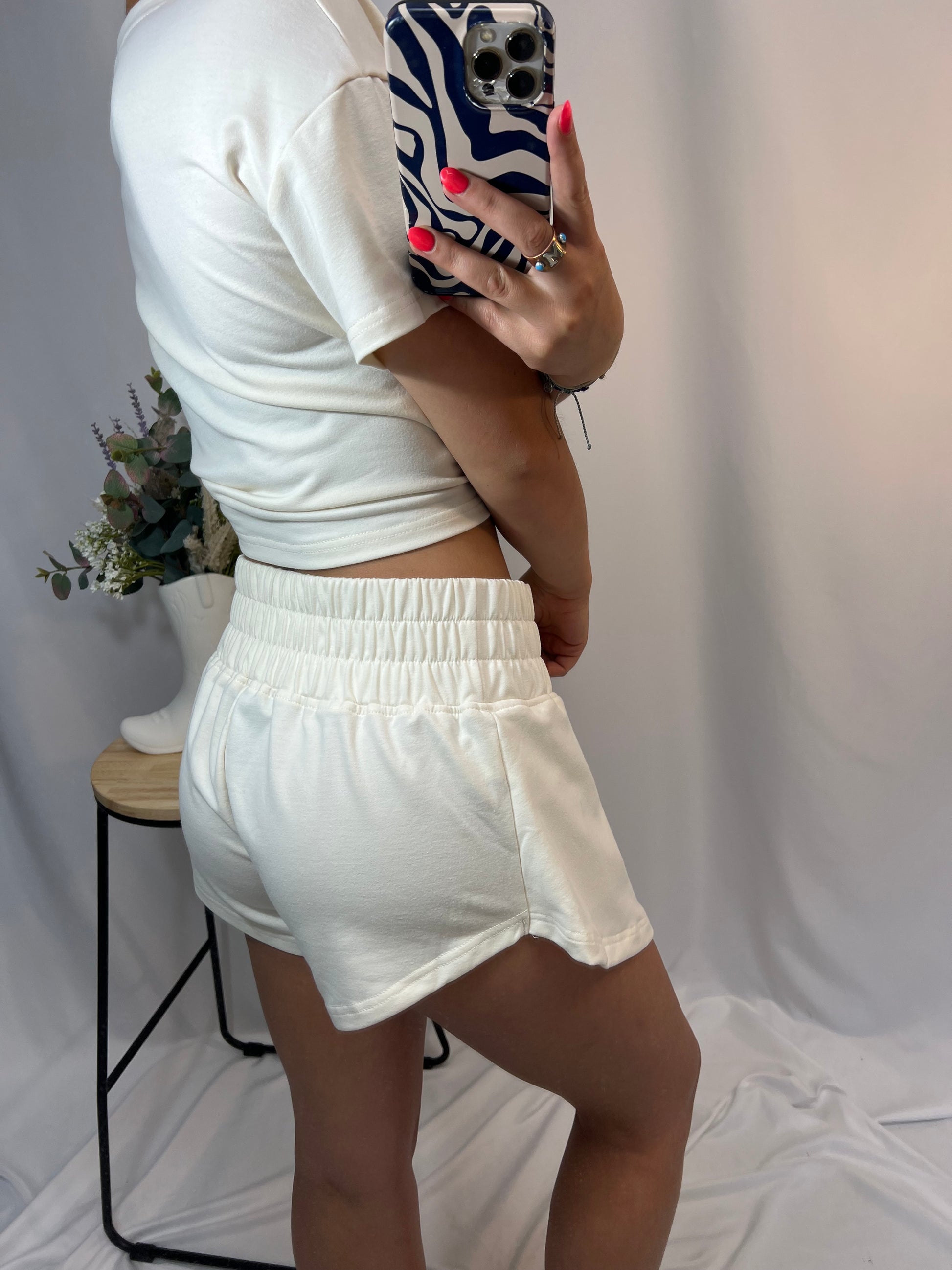 Back view of ivory cropped tee and ruffle high-waist skort set, women’s matching top and skirt shorts outfit
